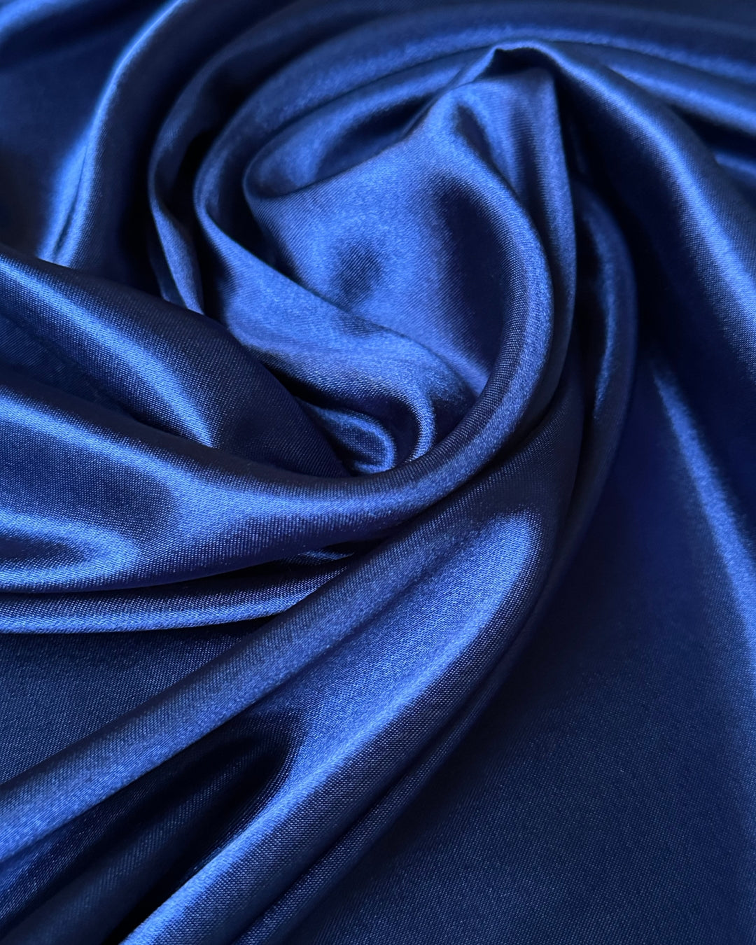 Close-up of blue satin scarf fabric with folds