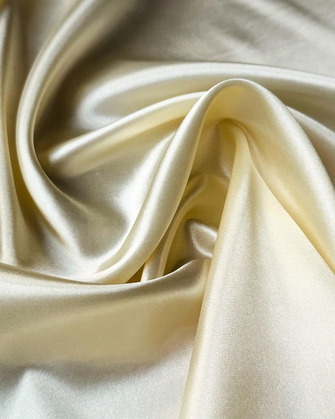 Close-up of beige satin scarf fabric with folds