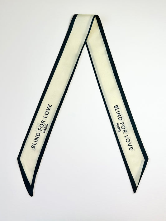 Black and white ribbon scarf with 'Blind for Love' text on a white background