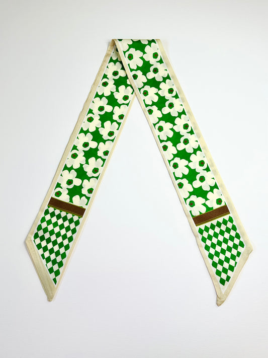 Green and white patterned ribbon scarf on a white background