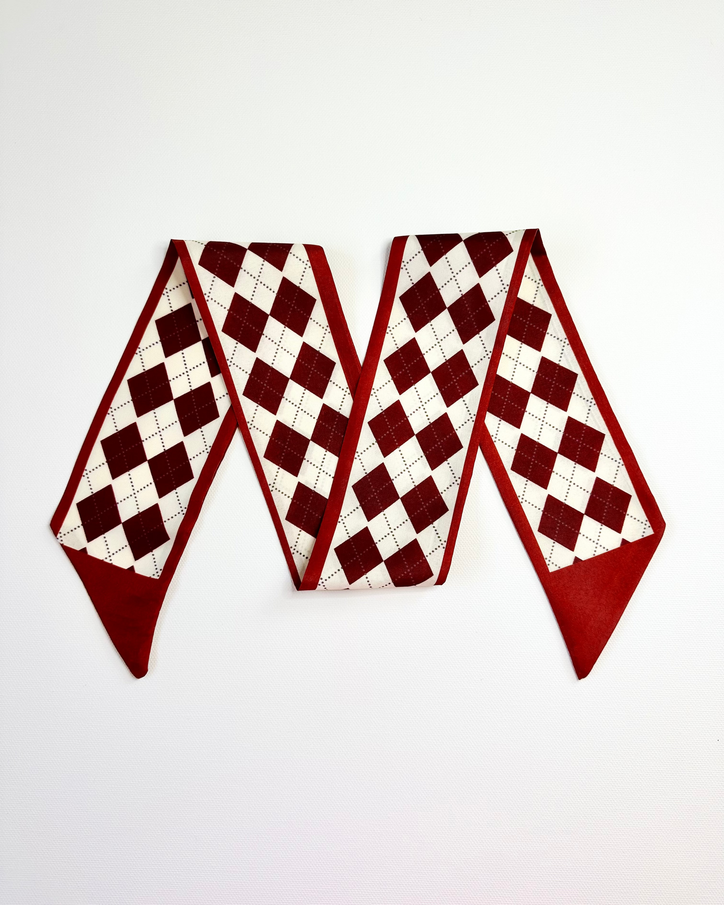 Decorative ribbon scarf with red and white checkered pattern on a plain background