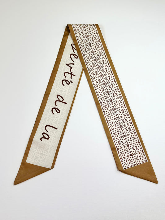 Decorative ribbon scarf with geometric pattern and text on a white background