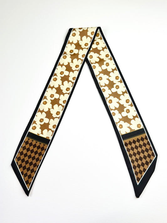 Decorative ribbon scarf with floral and checkered patterns on a white background