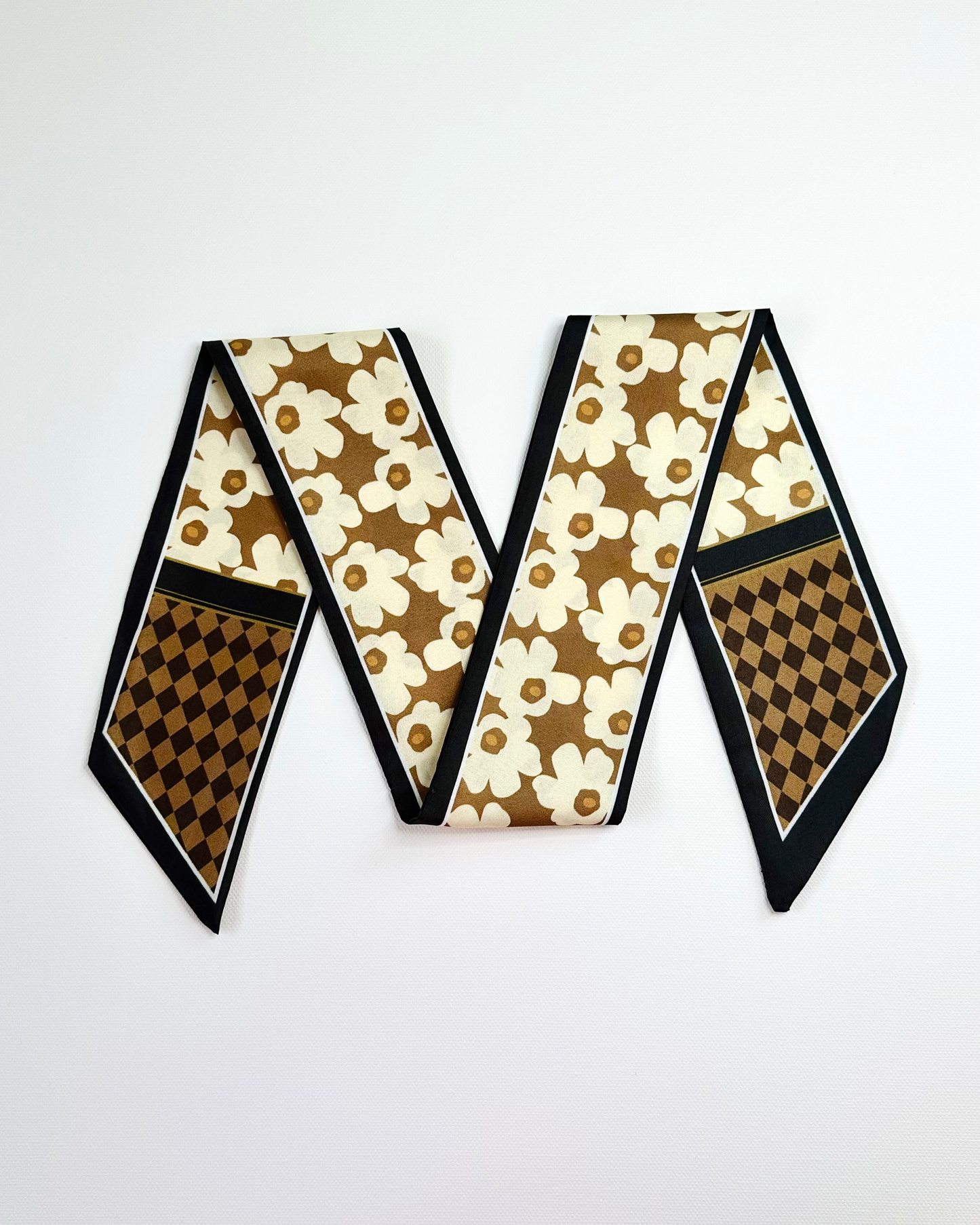 Ribbon scarf with floral and checkered patterns on a white background