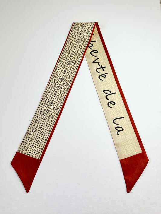 ribbon scarf with geometric pattern and text on a white background