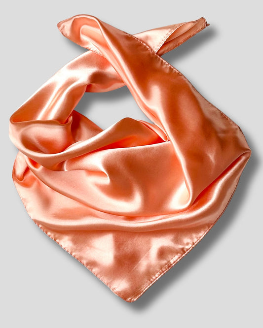 Pink peach satin scarf on a light gray background