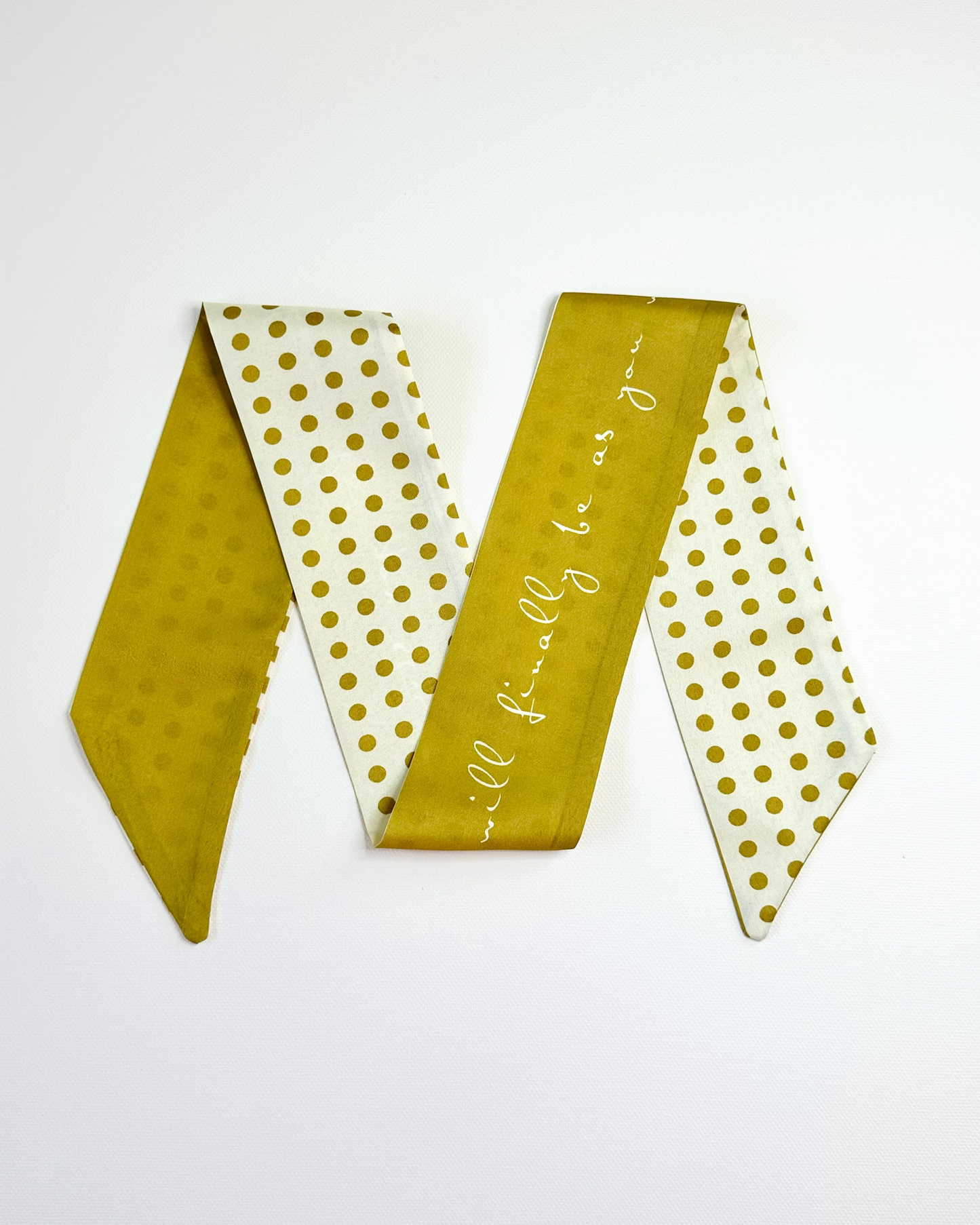 Gold and white polka dot ribbon scarf with text on a white background