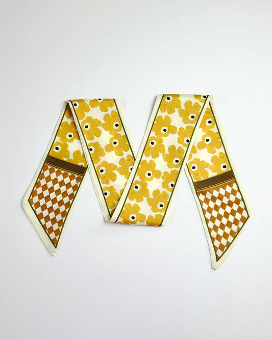 Ribbon scarf with floral and checkered patterns on a white background