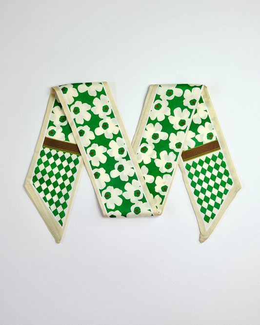 Green and white patterned ribbon scarf with a brown border on a light gray background