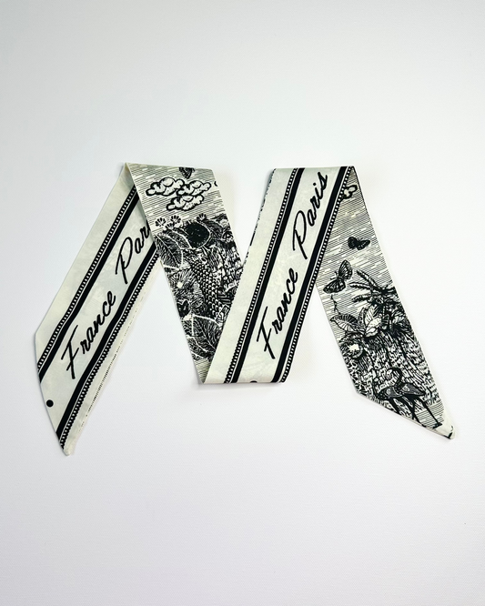 Decorative ribbon scarf with 'France Paris' text and black floral design on a white background