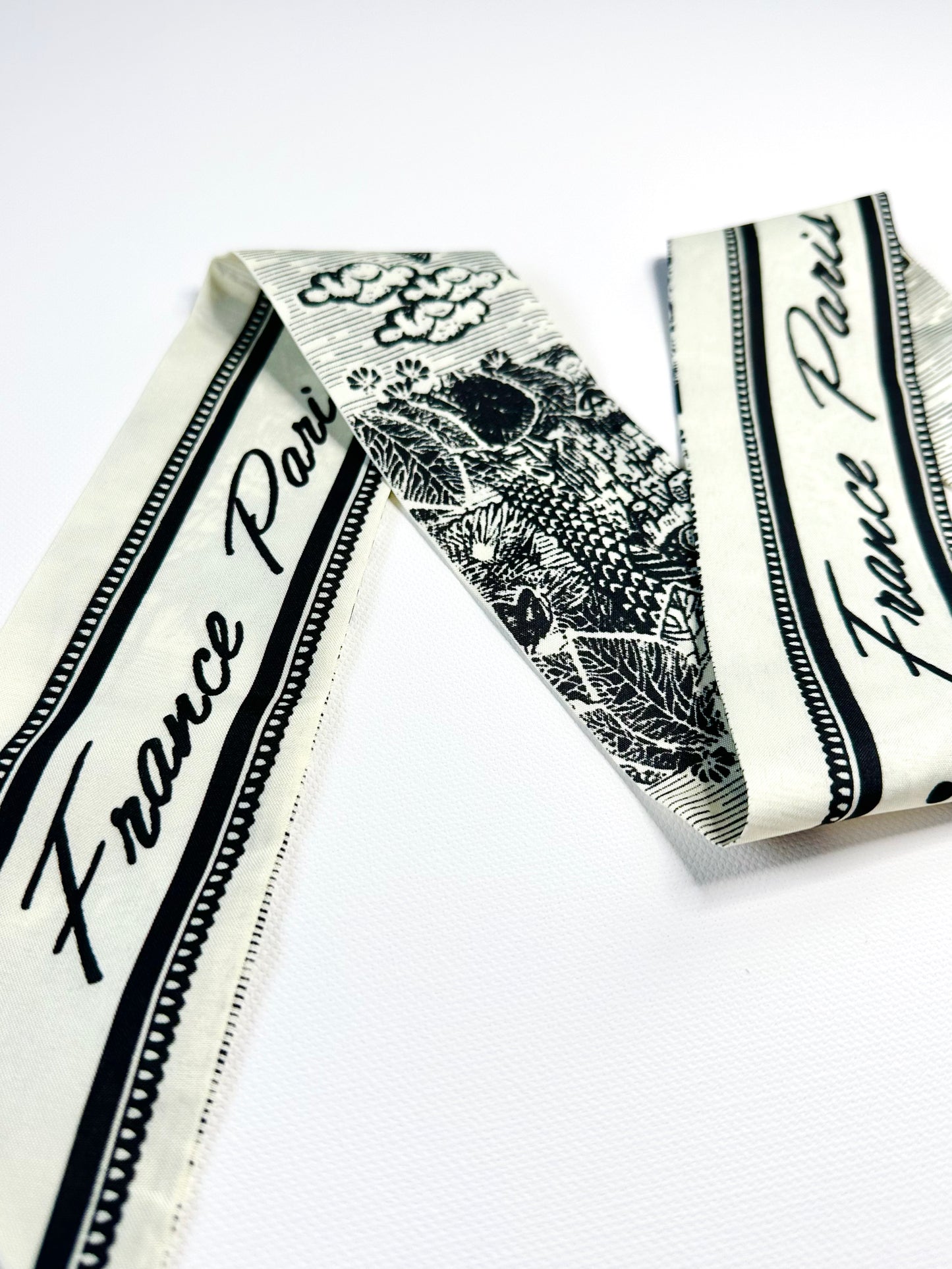 Decorative ribbon scarf with 'France Paris' text on a white background