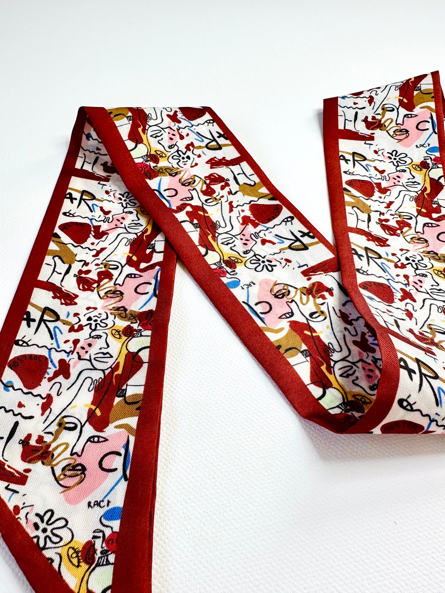 Colorful patterned ribbon scarf on a white background